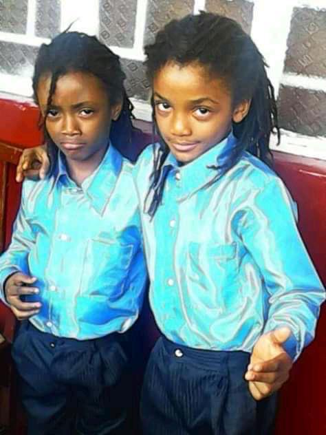 Young Jacob and Joseph Sesay in blue school uniforms