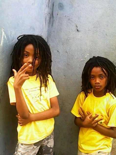 Young Jacob and Joseph Sesay in matching yellow Golden Twins Foundation tees