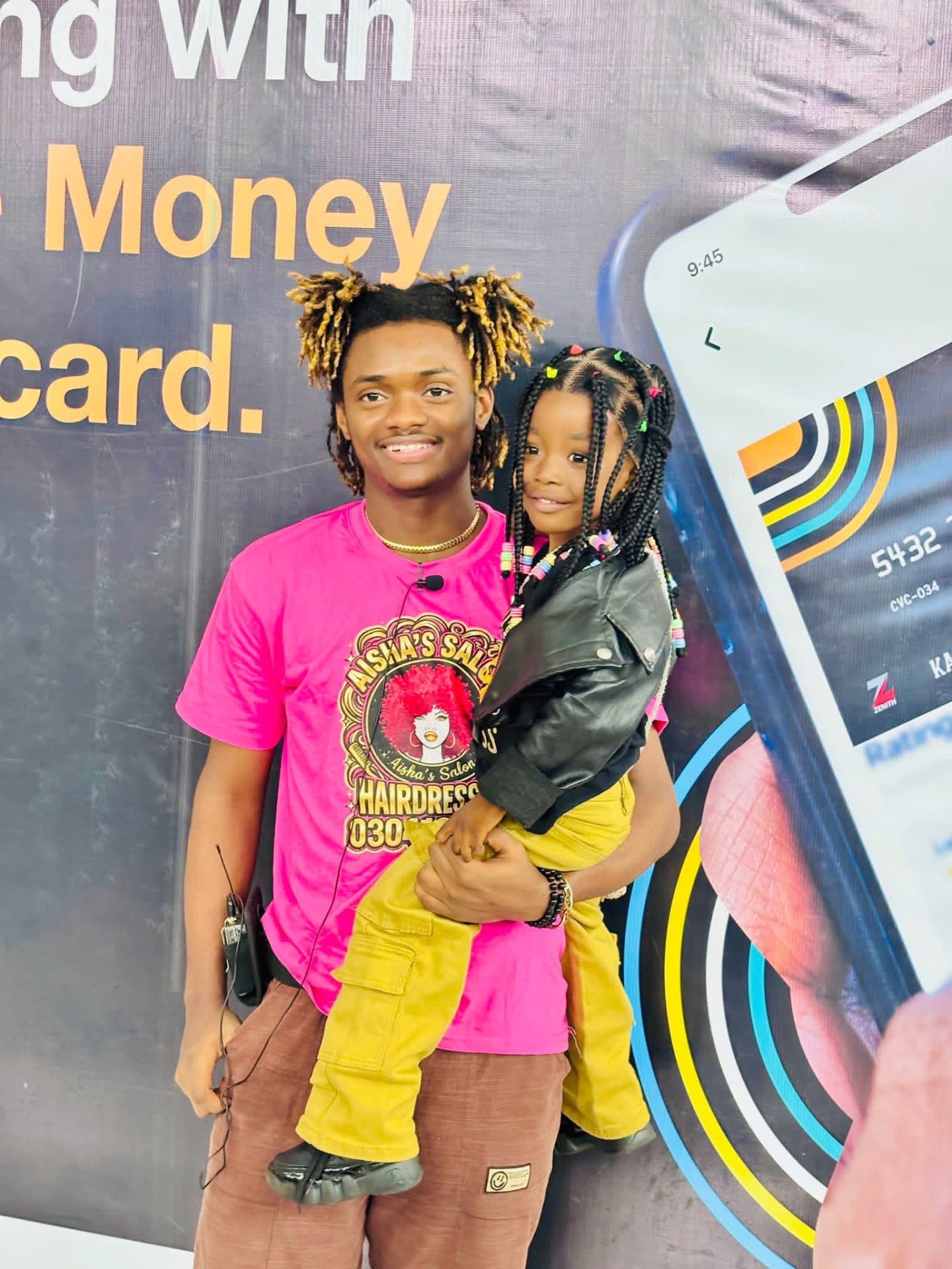 Jacob Sesay holding a young supporter during community outreach